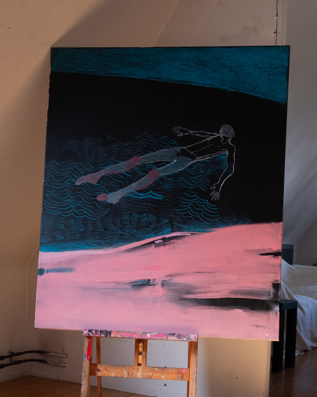 Painting of a swimmer in water with a pink and blue gradient background on an easel.