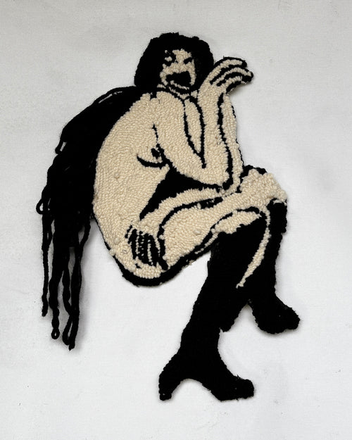 Handmade tapestry artwork of a nude figure in black and white, made from yarns.