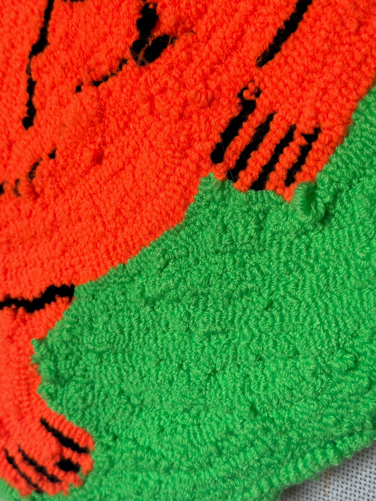 Close-up of a red and green knitted fabric with black patterns