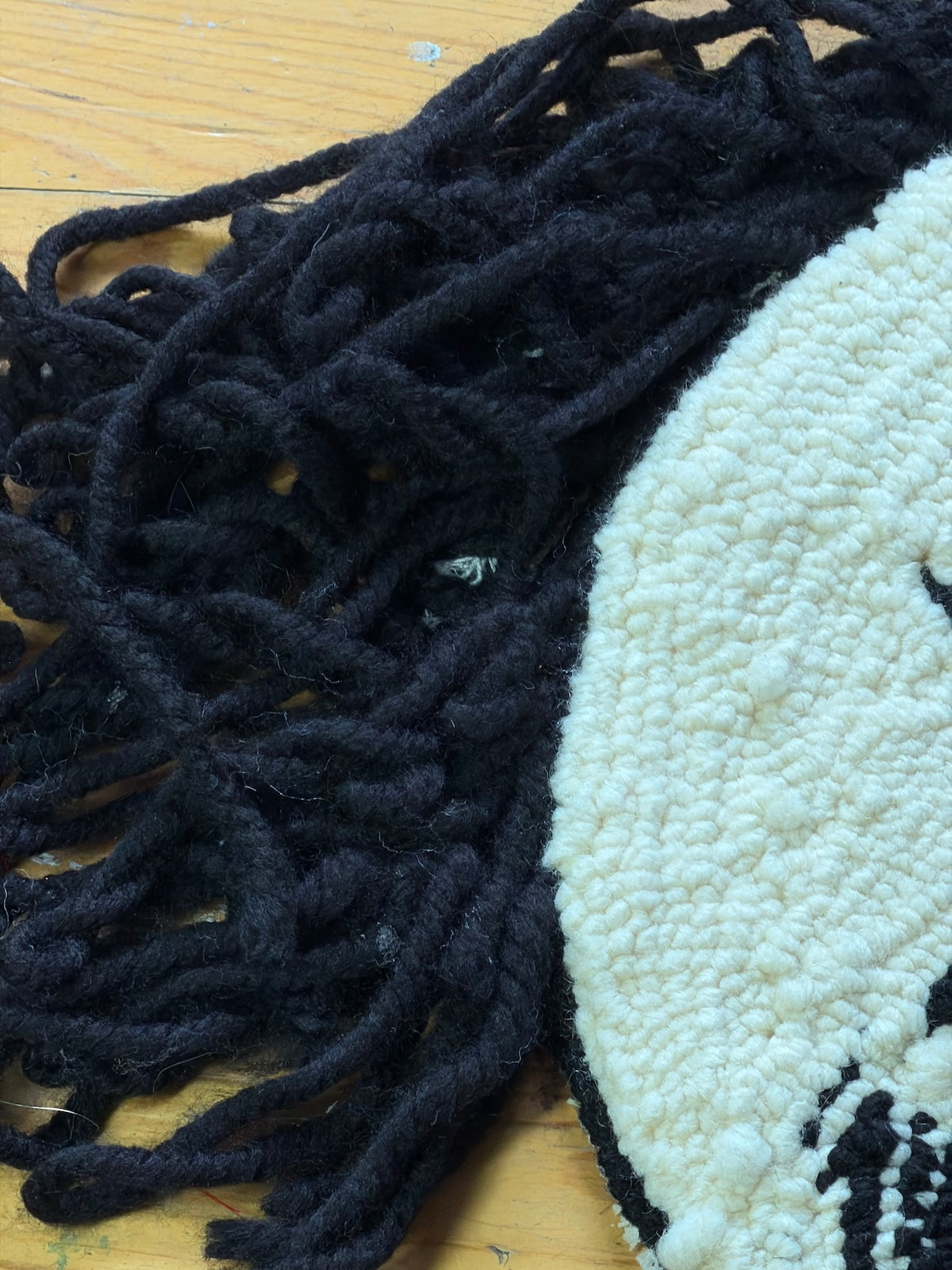 Close-up detail of Figure 13 tapestry by Studio Juuls showing the texture of hand-tufted yarn creating depth and shadow