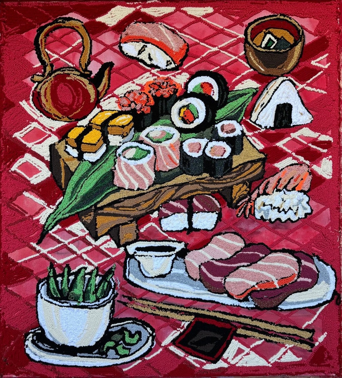 Textile tapestry of a sushi platter with various types of sushi on a red checkered tablecloth.