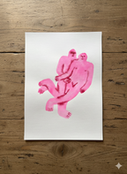 Pink abstract artwork made by watercolor on paper, showing two pink figures on a white sheet of paper, placed on a wooden surface.